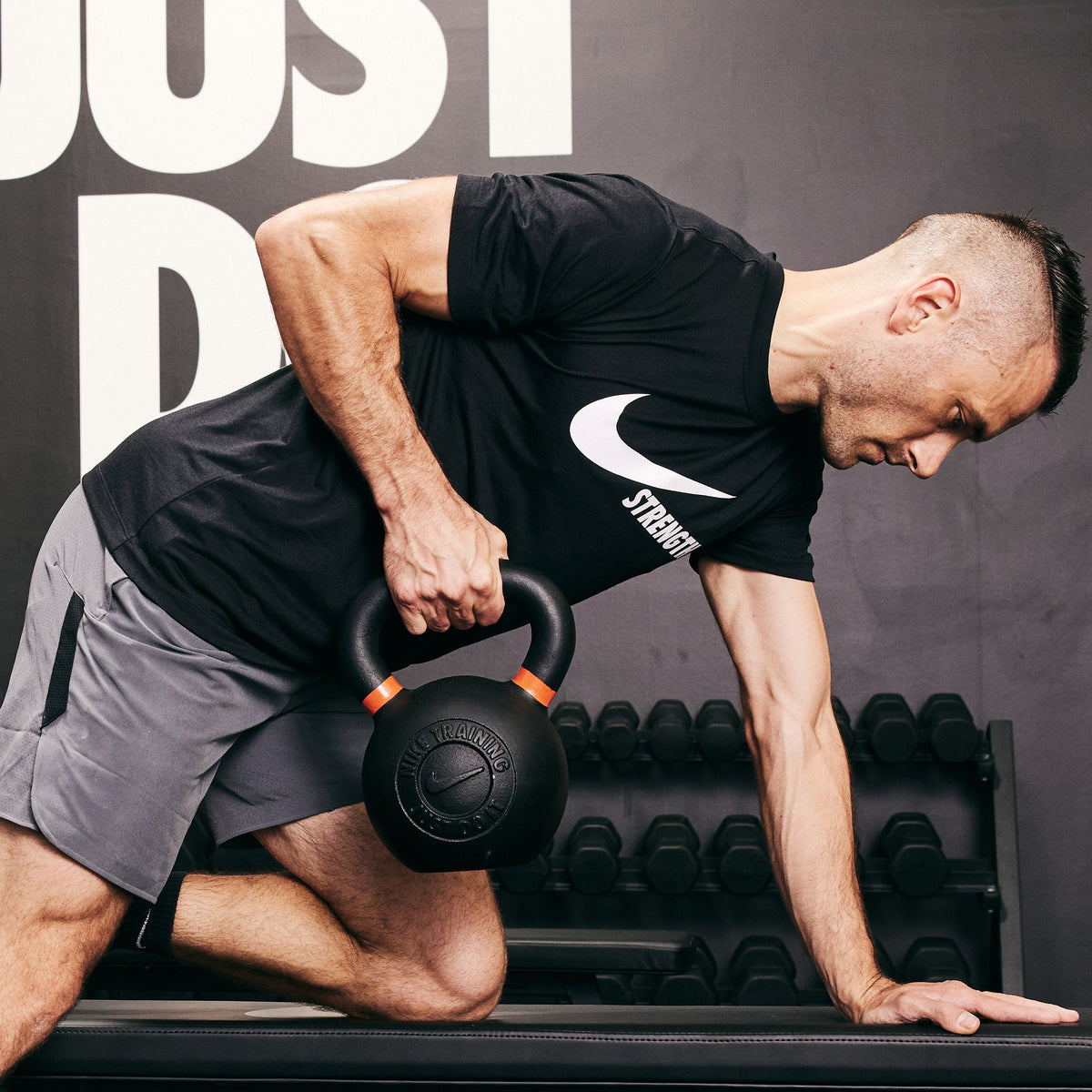 Male athlete rowing the Nike Kettlebell using the Nike Roller Bench