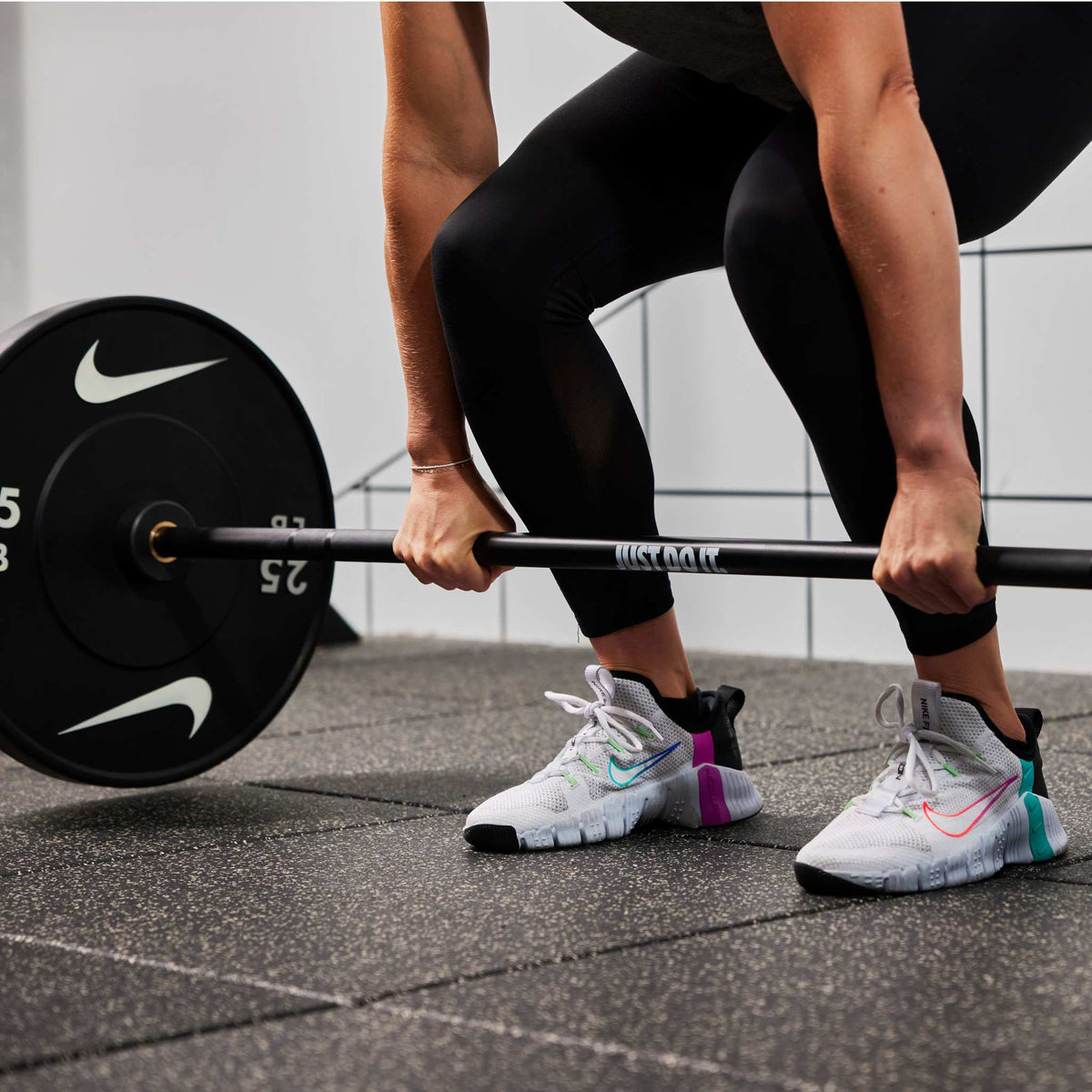 Athlete lifting the Nike coated Premium Barbell 15kg with Nike Rubber Bumper Plates